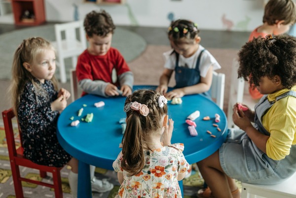 Group of toddlers collaboratively playing with colorful building blocks, developing fine motor skills and creativity at Quokka Kids