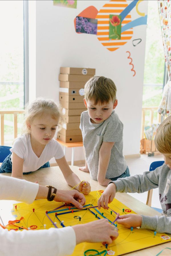 Group of toddlers collaboratively playing with colorful building blocks, developing fine motor skills and creativity at Quokka Kids