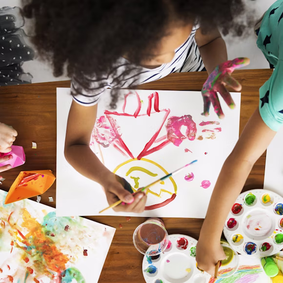 Dedicated preschool teacher reading an engaging storybook to a group of attentive children during Creative Curriculum time at Quokka Kids